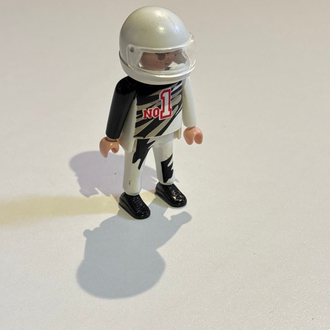 Playmobil race car driver toy figure wearing a white helmet and black/white suit with "No 1". on Save All