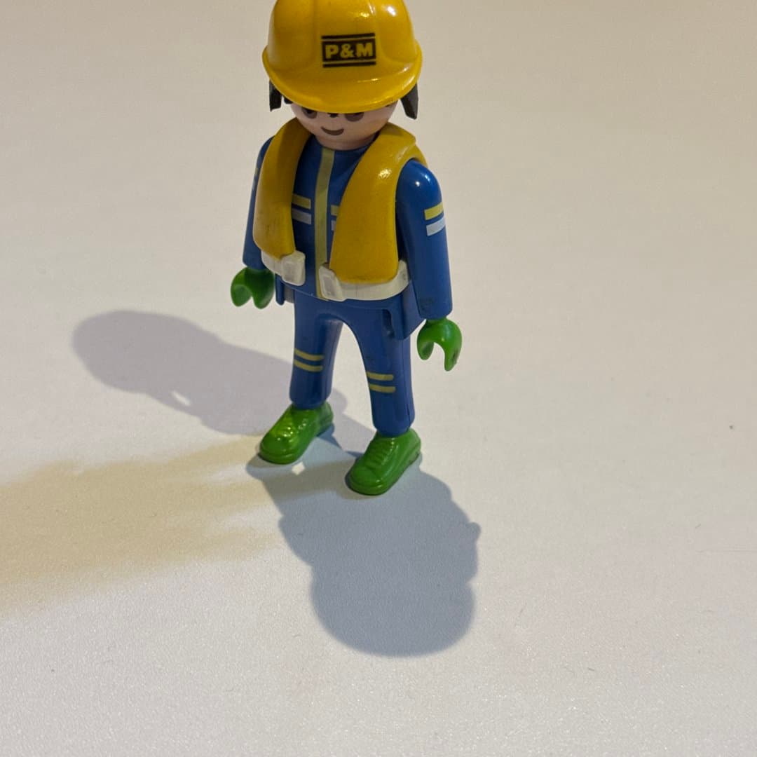 Playmobil-style Geobra 1992 worker figure in blue uniform, yellow safety vest & P&M hard hat. on Save All